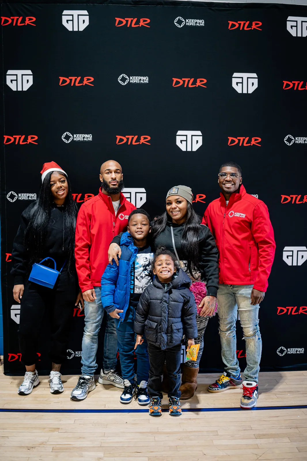 Families and KHA staff posing at the holiday toy drive photo wall