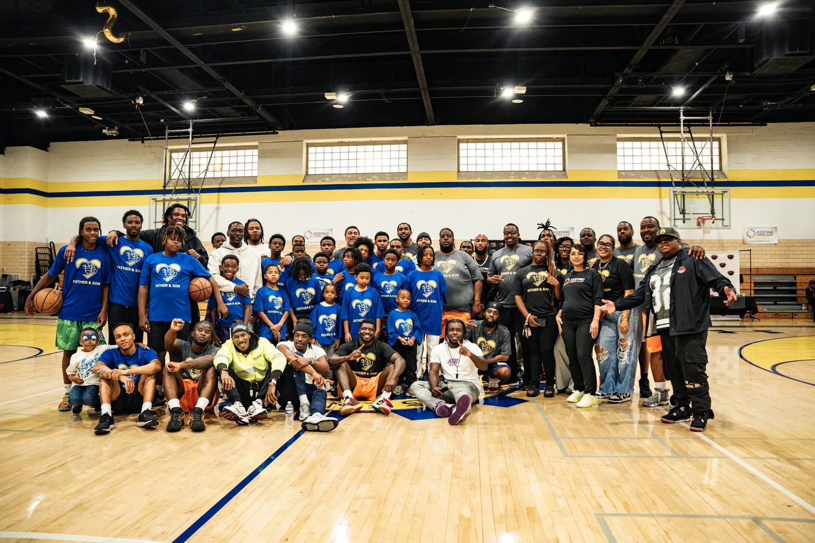 KHA youth, families and mentors gathered in a gym after a community event