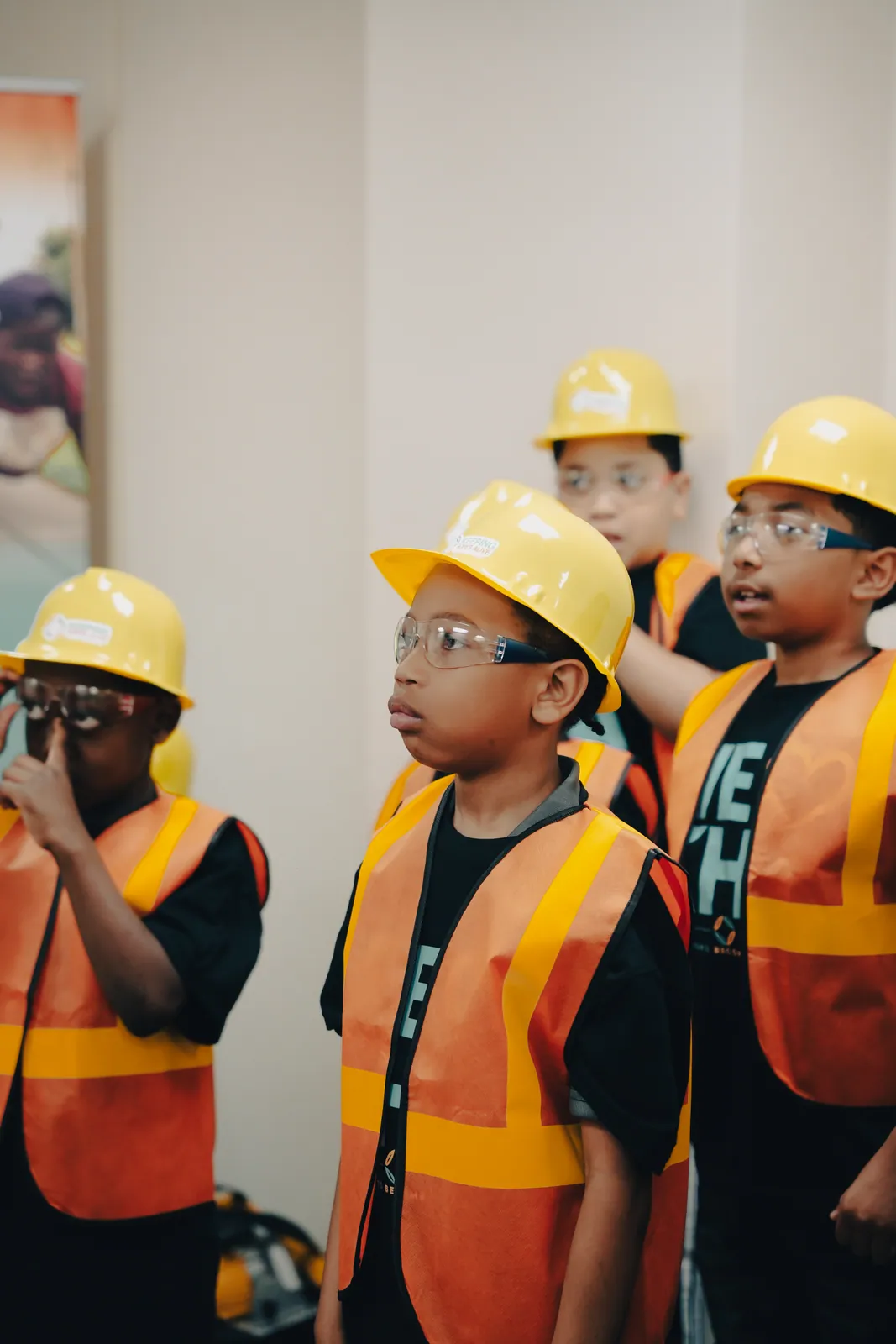 KHA youth in hard hats and safety vests at a construction workshop