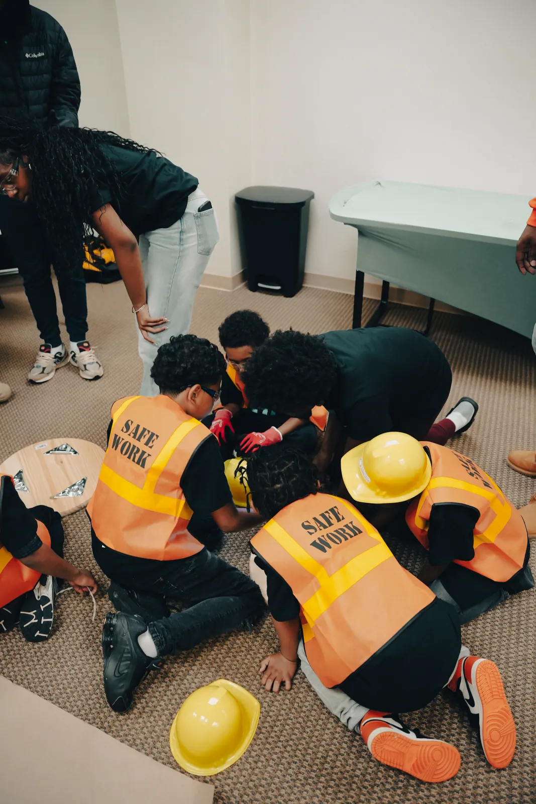 KHA youth working together on the floor during a hands on teamwork workshop