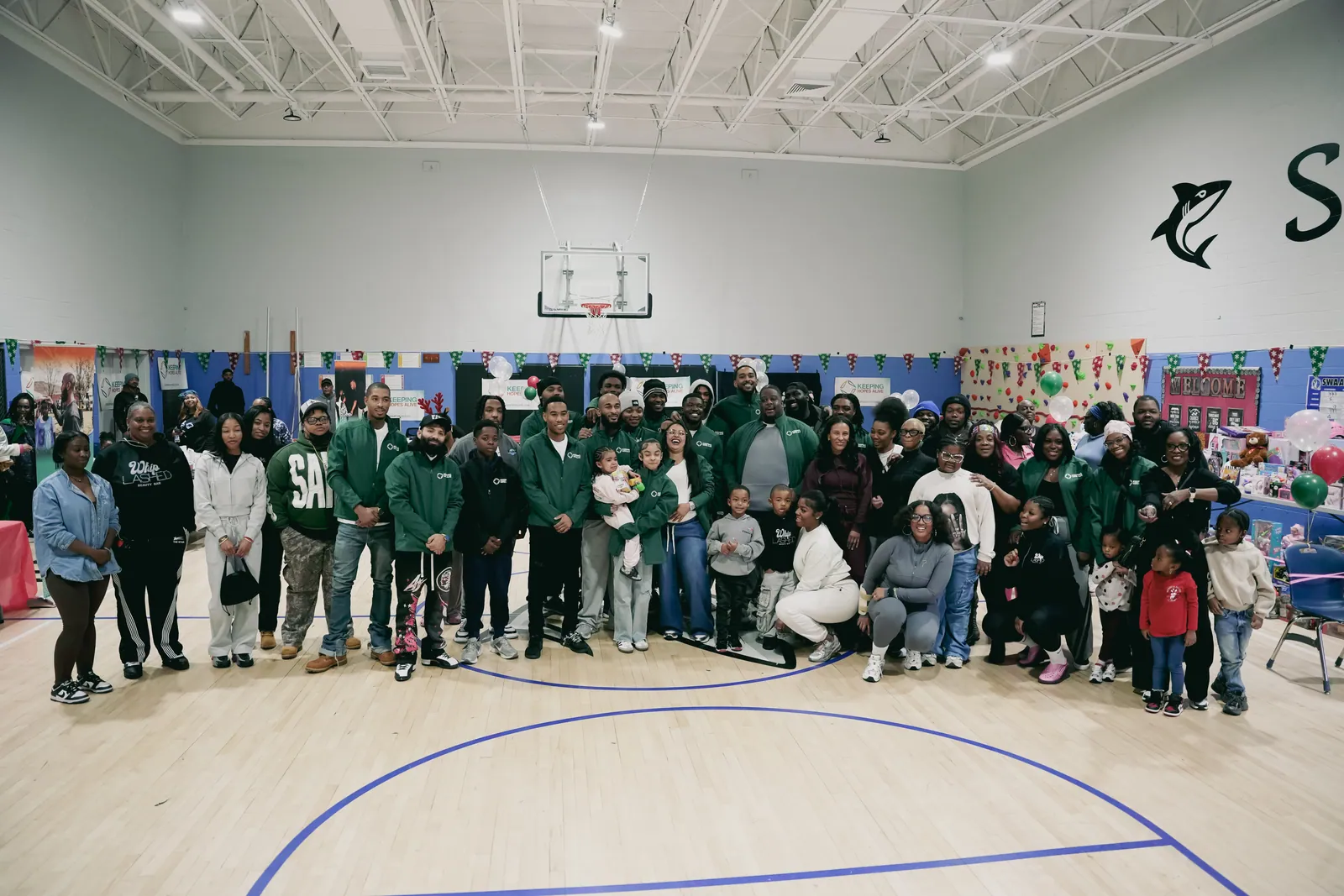 A large group of families and KHA staff in a gym during the holiday drive