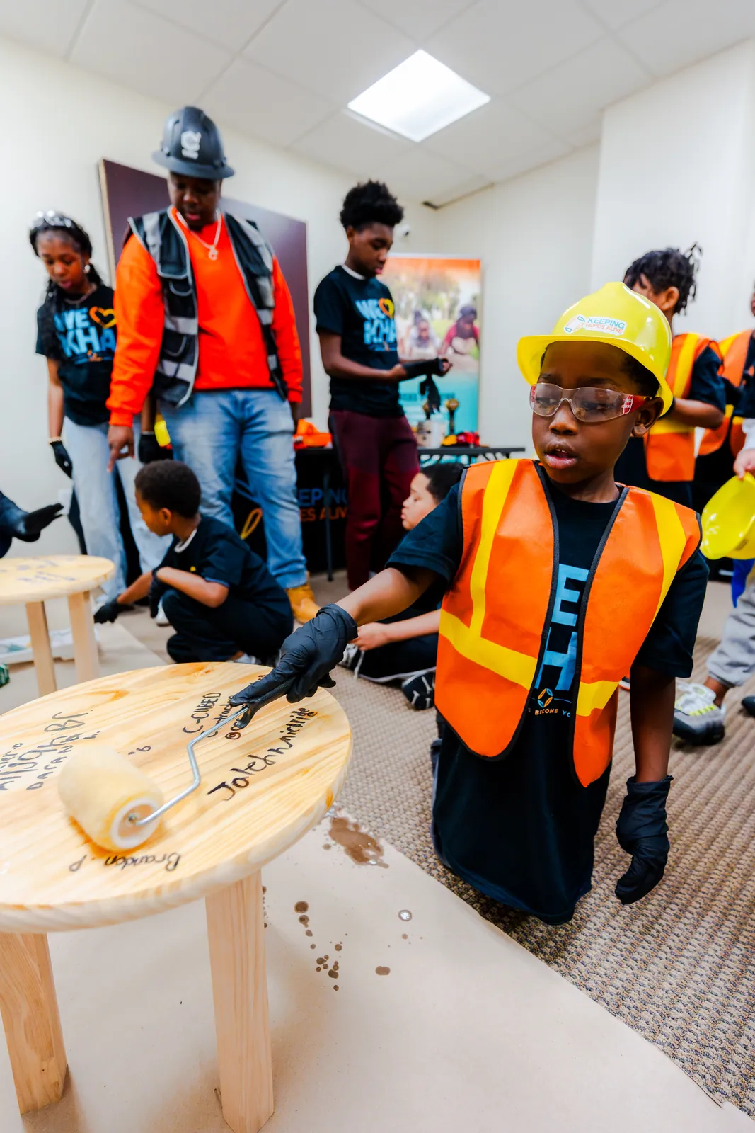 A young participant sanding wood during the KHA construction workshop